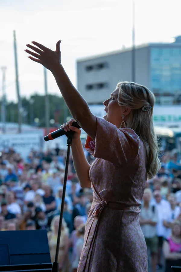 Laulaja nostaa kätensä kohti yleisöä Oulun Miljazz-konsertissa